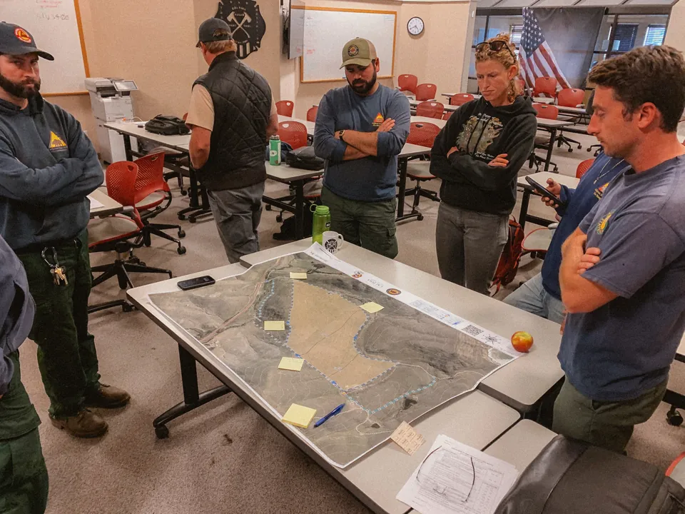 Partners reviewing a burn plan and program documents around a table