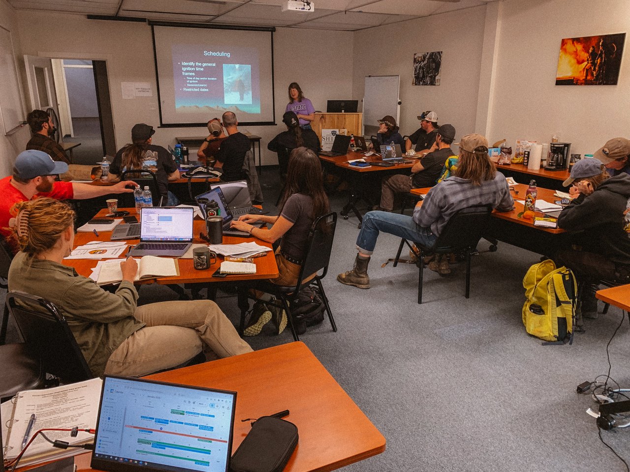 Partner staff and instructors working through program scope, schedules and documentation at laptops during a planning session